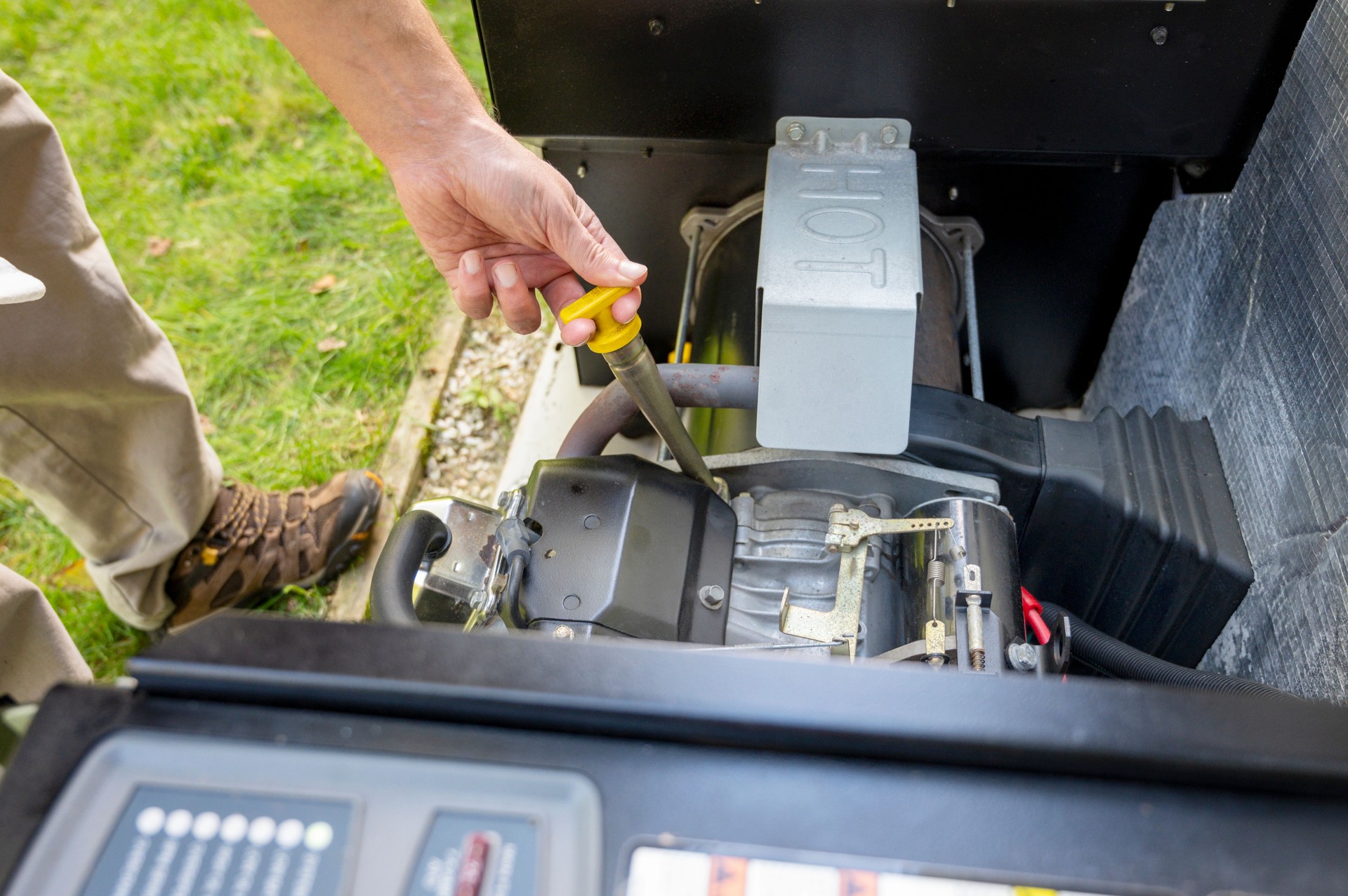 Man checking engine oil in generator, measuring oil level. Maintenance Mechanic Inspecting the generator.
